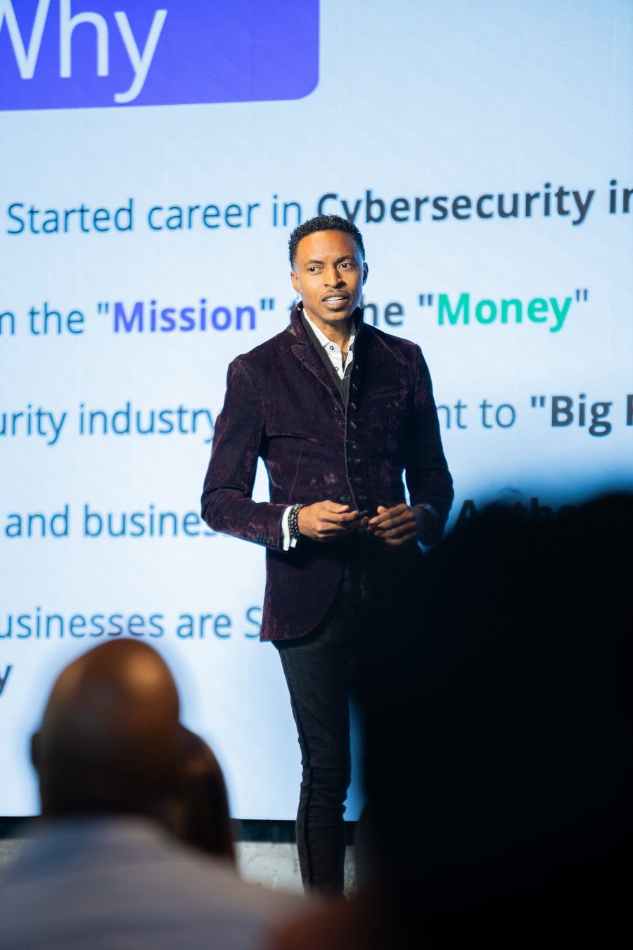 Corey White speaking on stage in front of his story slide